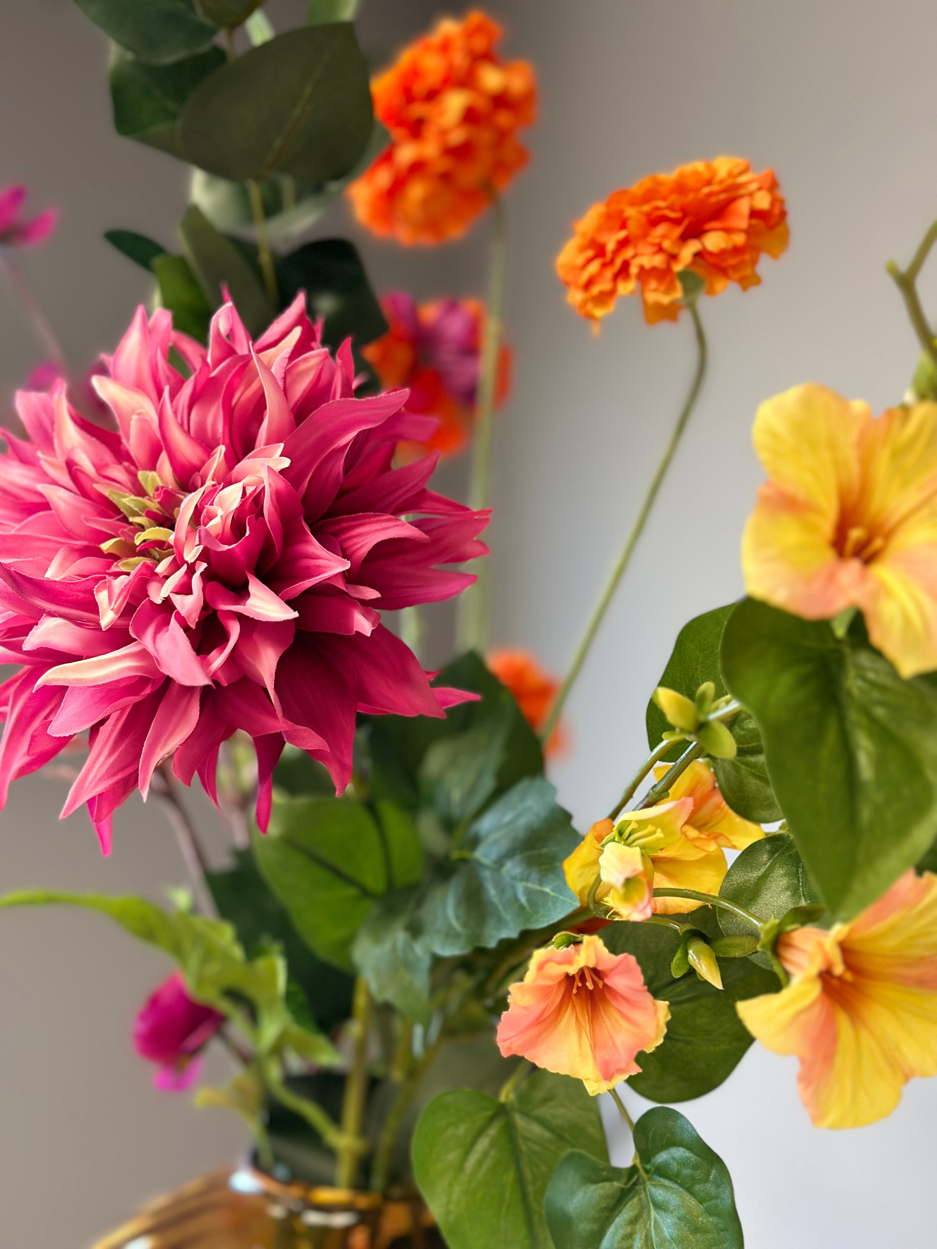 Detail van roze dahlia in een zijden bloem uitvoering. Samen met gele en oranje zijden bloemen. Onderdeel van zijden bloemenboeket Chloé van BloomFever.nl