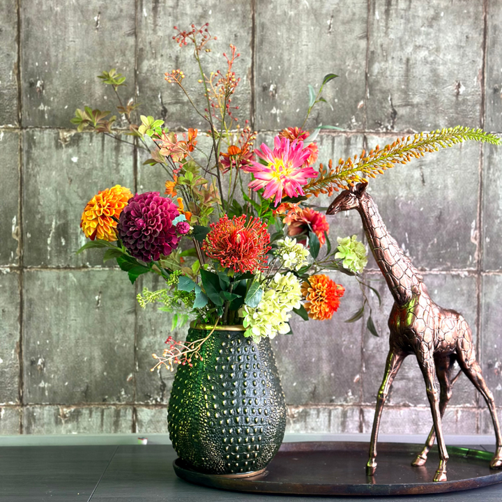 Zijdenbloemenboeket Ime van BloomFever in een groene crocodile vaas van PeriLiving, met levendige bloemen in roze, rood, oranje en groene tinten, die een kleurrijke en elegante uitstraling geven aan het interieur.