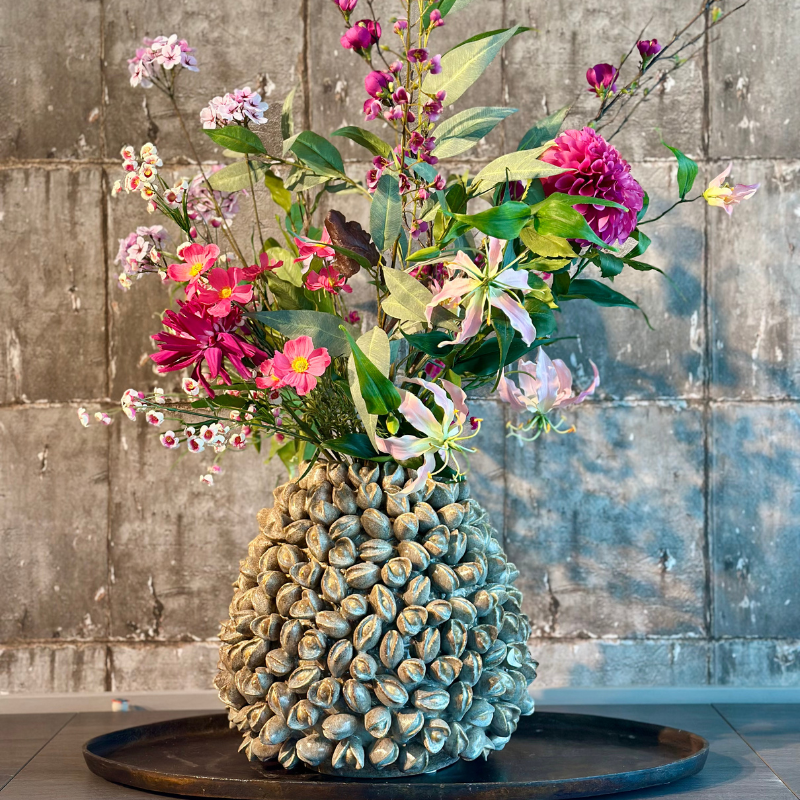 Zijdenbloemenboeket Scottie in de keramieke Pistache L vaas van PeriLiving, met vrolijke kleuren zoals roze en groen, gecombineerd met pistache nootjes in het ontwerp van de vaas, die een frisse lente-uitstraling geven aan het interieur.